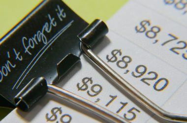 Close-up image showcasing a binder clip on a detailed financial report with highlighted amounts.